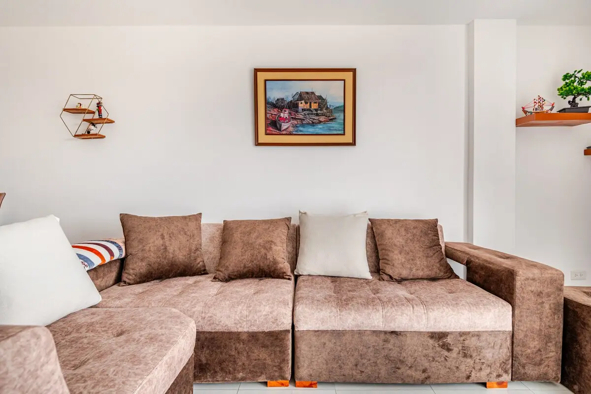 Living room with a comfortable sofa and daylight in the Perla de la Montaña apartment, Quito