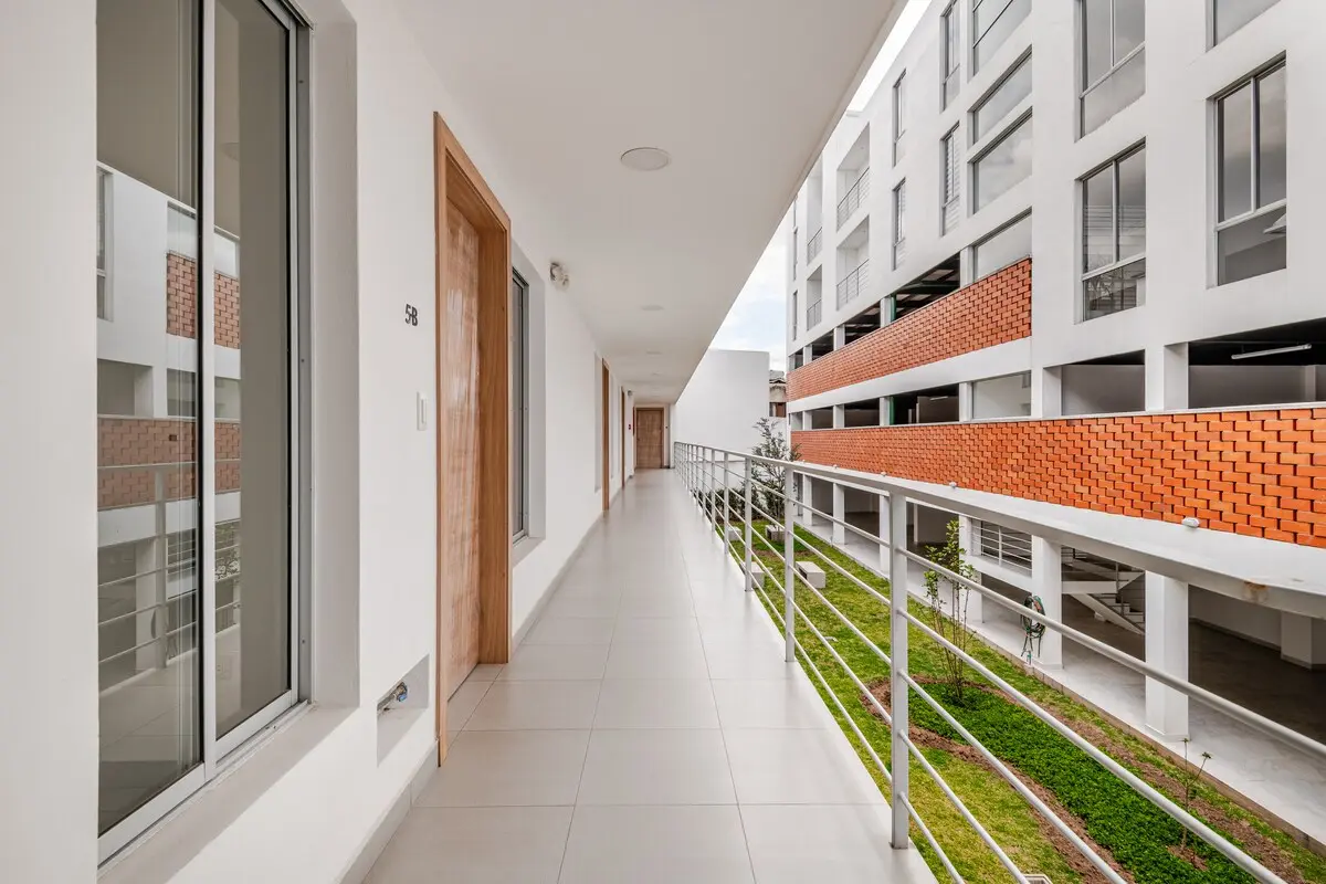 Bright shared walkway with a garden courtyard in the newly built Perla de la Montaña building in San Juan, Quito