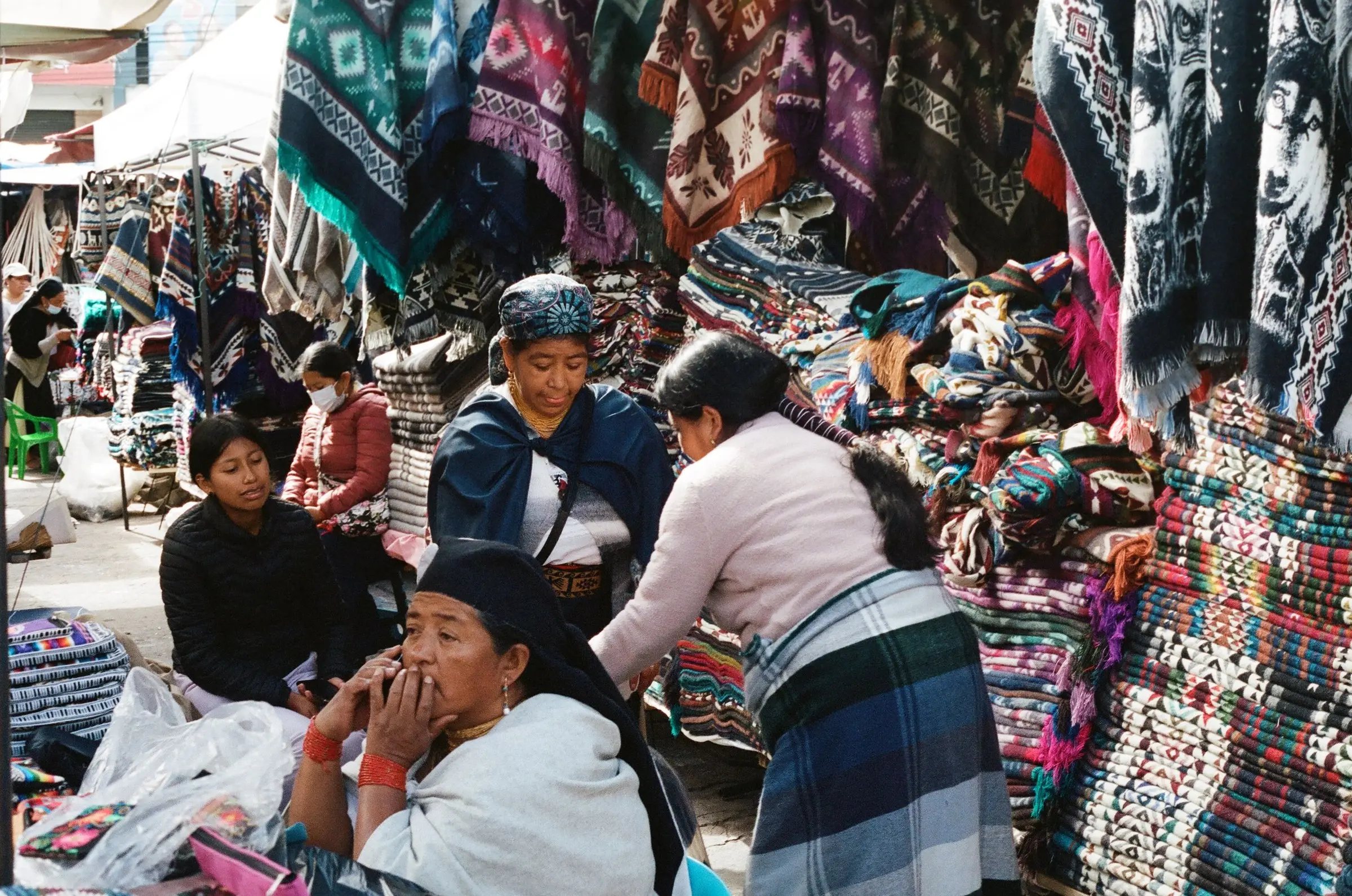 Colorful ponchos and woven blankets on display at the Otavalo craft market north of Quito